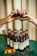 Load image into Gallery viewer, A beautifully arranged gift set of 8 bottles of Brooklyn Brewed Sorrel mocktail, each decorated with a thin red ribbon in a festive wedding party setting. This healthy, nut-free spiced hibiscus roselle beverage is crafted in an allergen-free facility. An ideal alcohol-free gift from a Black-owned, Woman-owned, and Caribbean-owned business, perfect for weddings, Dry January, Passover, Father's Day, or Mother's Day.